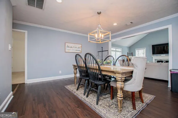 a view of a dining room with furniture a chandelier and wooden floor