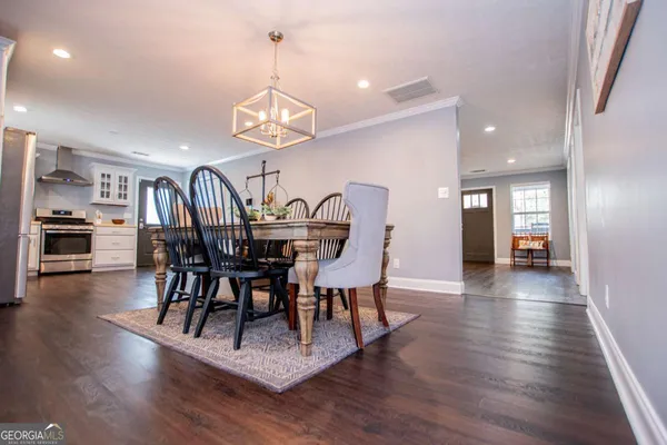 a view of a dining room with furniture wooden floor and chandelier