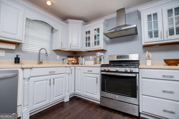 a kitchen with cabinets stainless steel appliances a sink and wooden floor