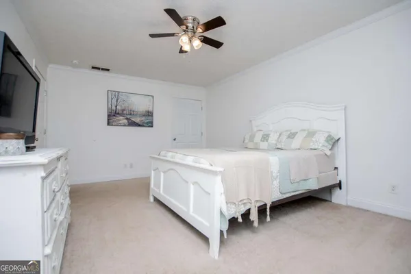 a spacious bedroom with a bed and a flat screen tv