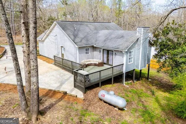 a view of a house with wooden deck and a backyard
