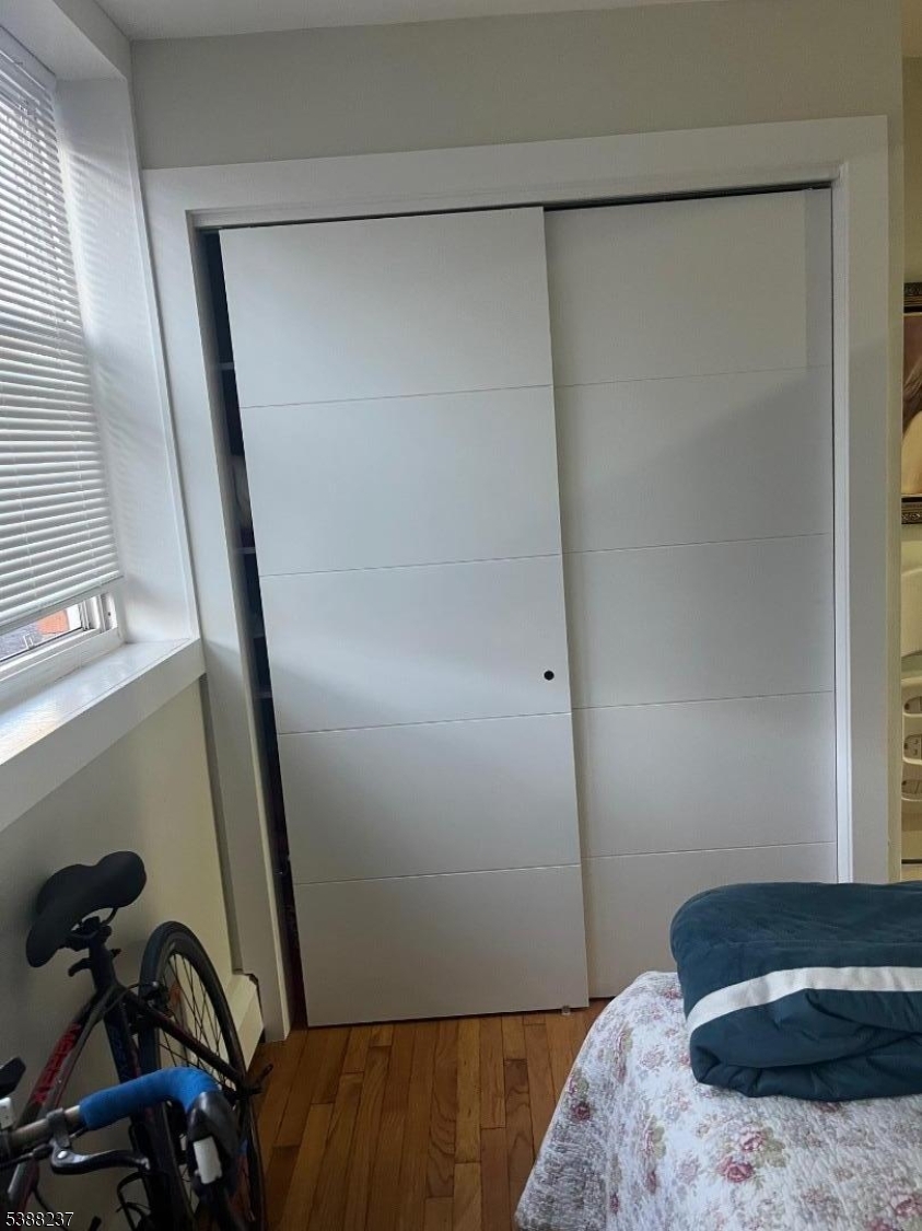 744 Hazard Place, Unit 1F Elizabeth, NJ 07208 - Photo 11 of 12 a bedroom with a bed and a mirror