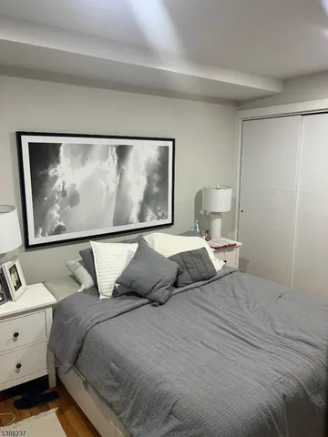 a bedroom with a bed and a flat tv screen on dresser