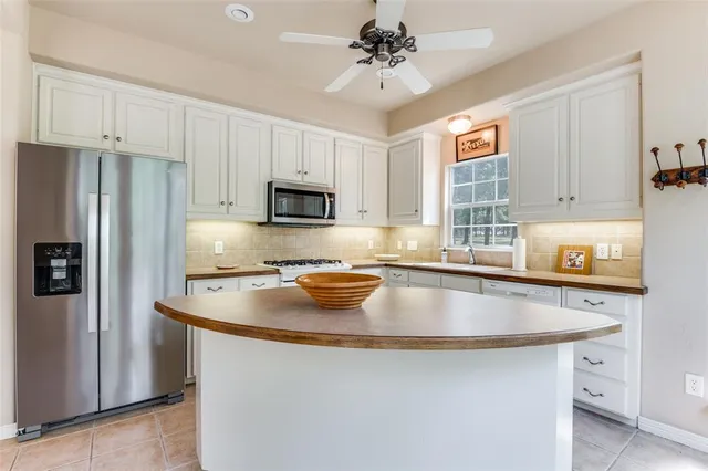 a kitchen with stainless steel appliances granite countertop a sink a refrigerator a stove a microwave and cabinets