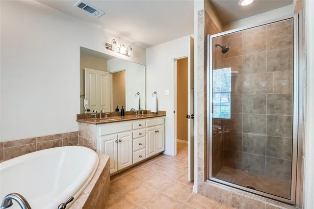 a bathroom with a granite countertop tub sink shower and mirror