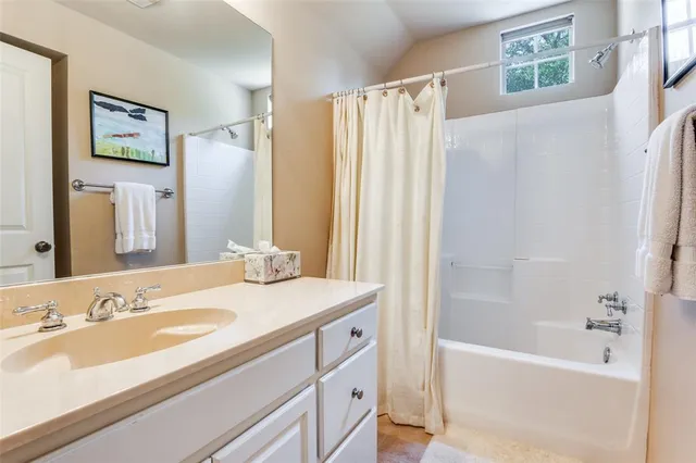 a bathroom with a granite countertop sink a mirror a shower and a bathtub