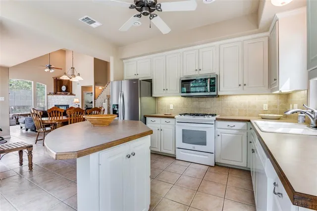 a kitchen with cabinets appliances a sink and a counter top space