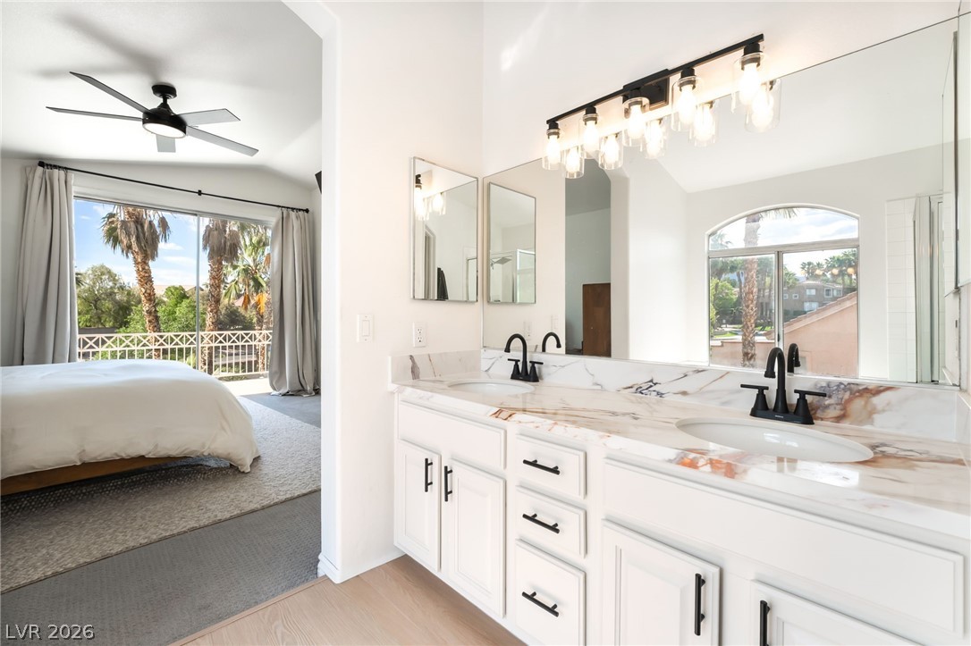 1941 Ivy Point Lane Las Vegas, NV 89134 - Photo 15 of 21 This primary bathroom offers a dual vanity with a patterned countertop and a view into the adjoining bedroom.