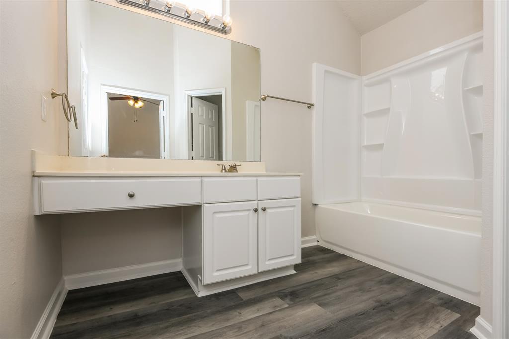 6900 Chaco Trail Fort Worth, TX 76137 - Photo 11 of 17 a bathroom with a sink a mirror and a bathtub