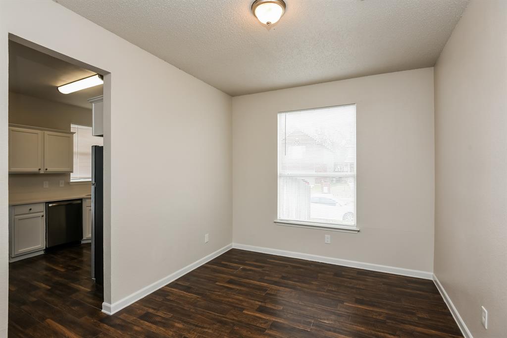 6900 Chaco Trail Fort Worth, TX 76137 - Photo 5 of 17 an empty room with wooden floor cabinet and windows