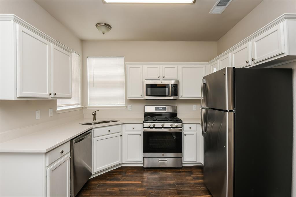 6900 Chaco Trail Fort Worth, TX 76137 - Photo 7 of 17 a kitchen with stainless steel appliances a refrigerator stove and microwave