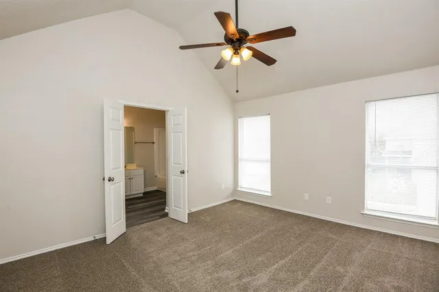 an empty room with closet and a chandelier fan