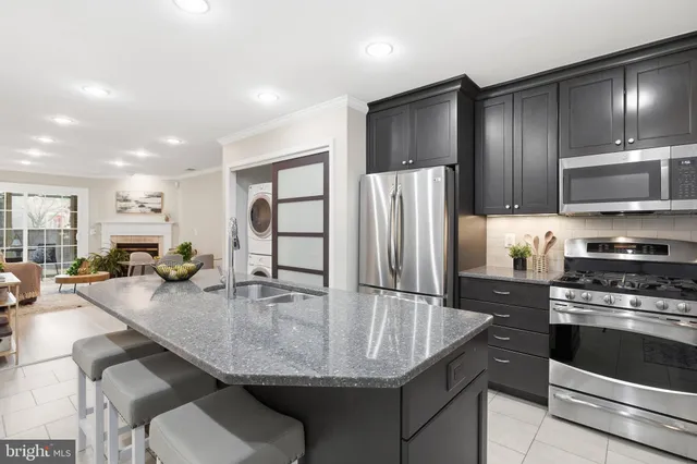 a kitchen with stainless steel appliances granite countertop a sink a microwave and wooden cabinets