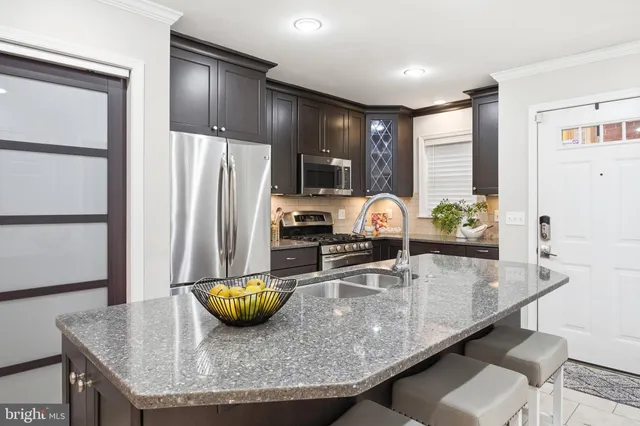 a kitchen with granite countertop a counter space and stainless steel appliances