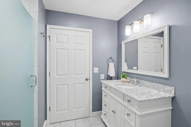 a bathroom with a granite countertop sink and a mirror