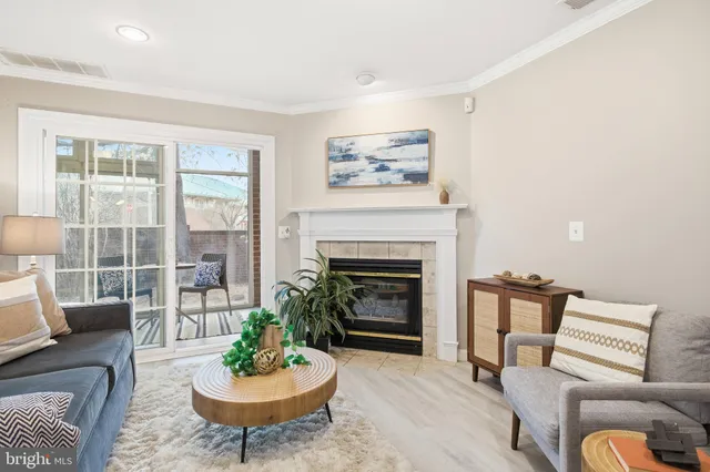 a living room with furniture a fireplace and a large window