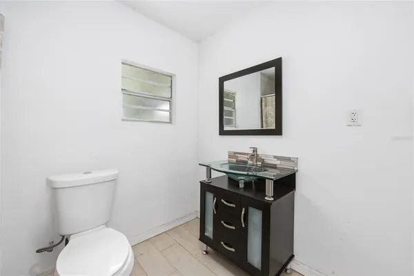 a bathroom with a toilet a sink and mirror