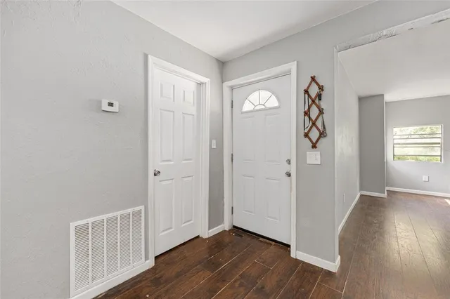 a view of an empty room and window and wooden floor