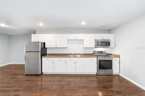 a kitchen with stainless steel appliances white cabinets and a refrigerator