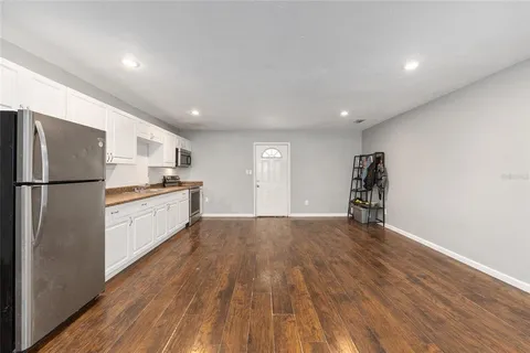 a spacious bedroom with a bed and a flat screen tv