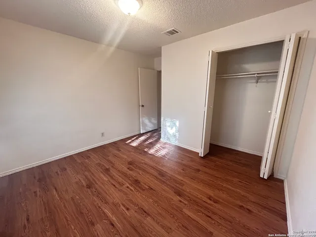an empty room with wooden floor and entrance