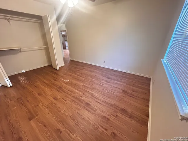 a view of empty room with wooden floor