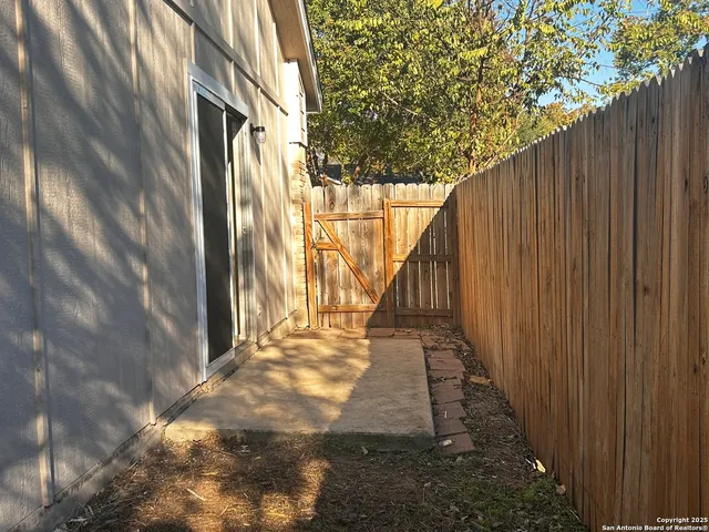 a view of a pathway of a house with wooden fence
