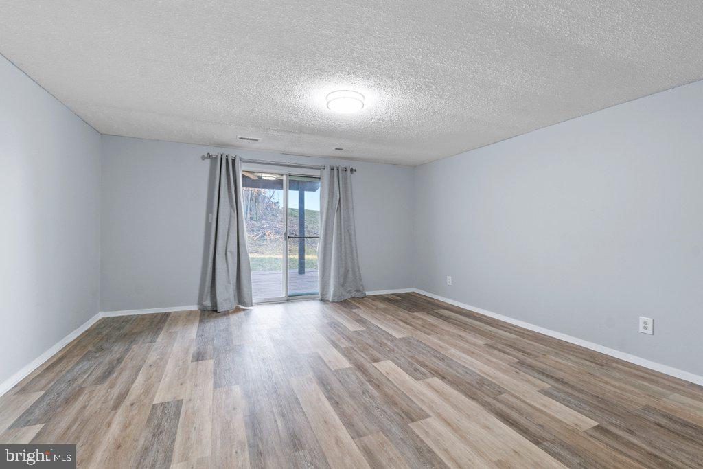 2412 Potterfield Road Windsor Mill, MD 21244 - Photo 34 of 36 a view of an empty room with wooden floor and a window