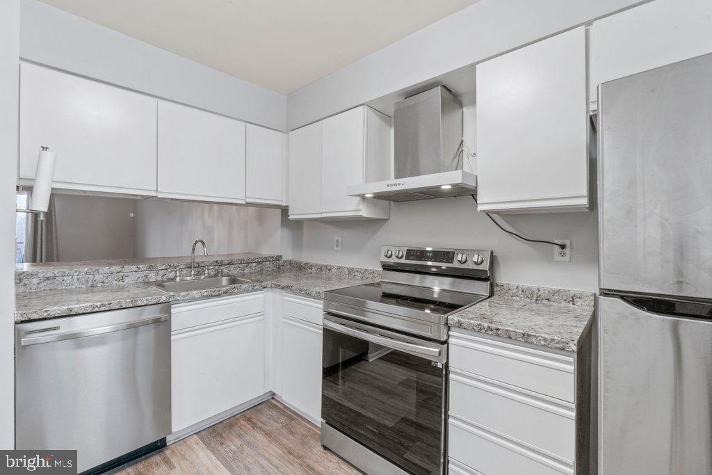 2412 Potterfield Road Windsor Mill, MD 21244 - Photo 10 of 36 a kitchen with white cabinets and appliances