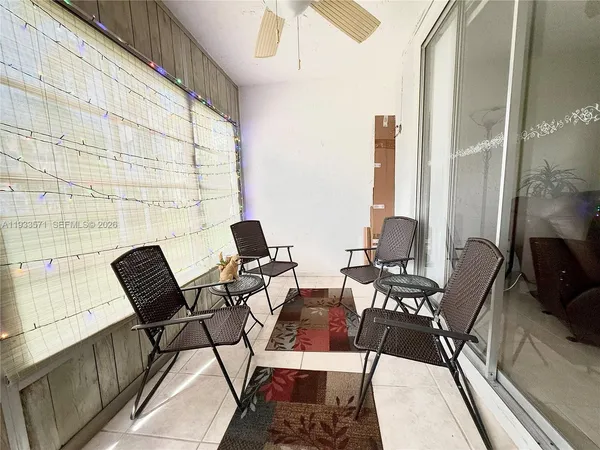 a view of a balcony with chairs and a potted plant