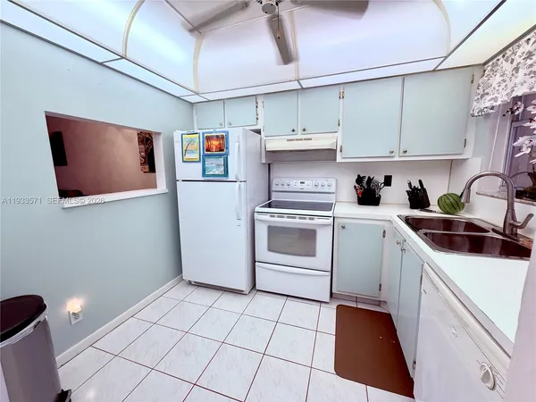 a kitchen with stainless steel appliances a sink a stove a refrigerator and cabinets