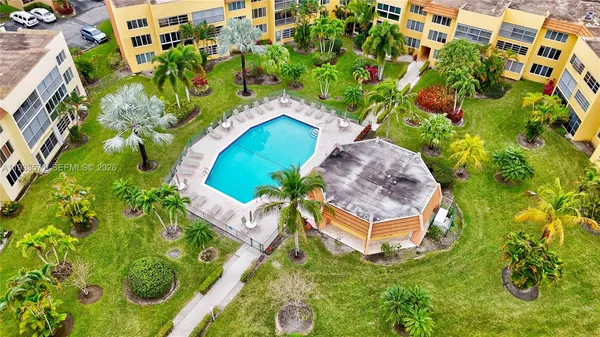 an aerial view of a house with a yard and large trees