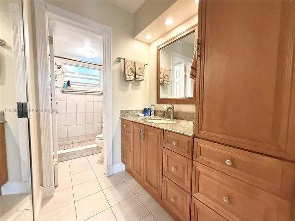 a bathroom with a granite countertop sink a mirror and a bathtub