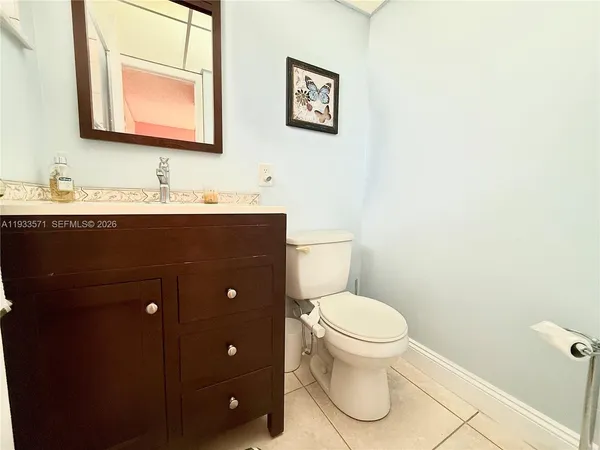 a bathroom with a toilet a sink a mirror and vanity