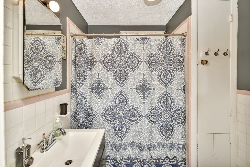 42 Vernon Street Boston, MA 02136 - Photo 8 of 12 a bathroom with a shower curtain and a sink