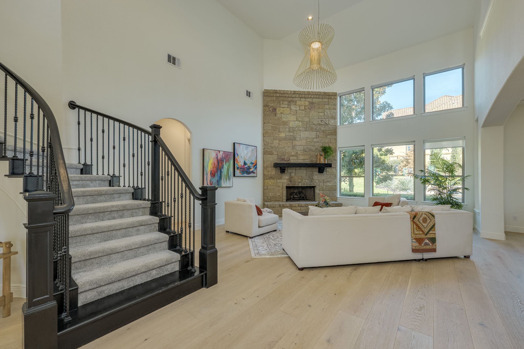 11612 Shoreview Overlook Austin, TX 78732 - Photo 10 of 40 Double-height windows illuminate the soaring living space anchored by a floor-to-ceiling stone fireplace.