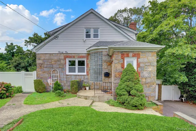 a front view of a house with a garden and plants