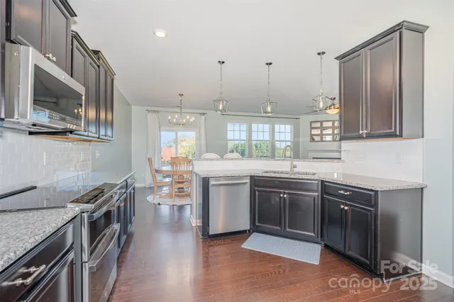 a kitchen with stainless steel appliances granite countertop a stove and cabinets