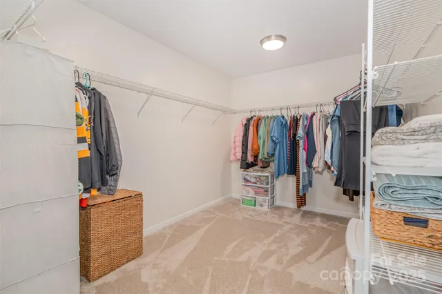 a view of walk in closet with clothes