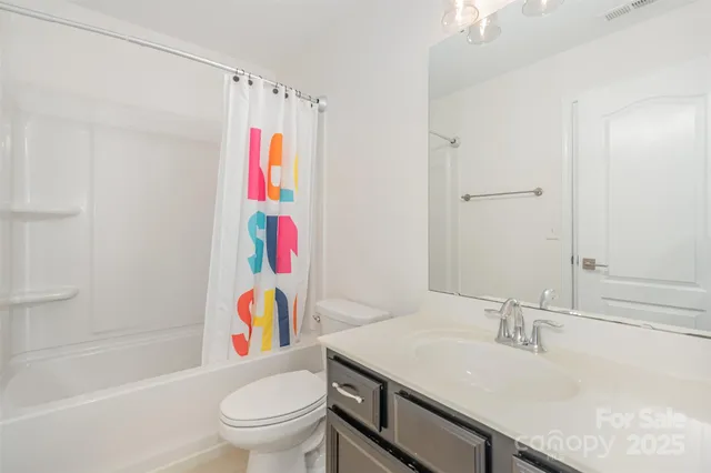 a bathroom with a sink a toilet and a shower curtain