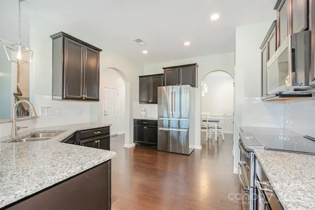 a kitchen with stainless steel appliances granite countertop counter space a sink refrigerator and cabinets