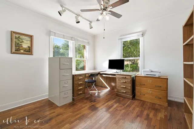 a view of a workspace with furniture and a window