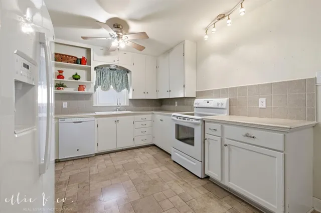 a kitchen with cabinets stainless steel appliances and a chandelier