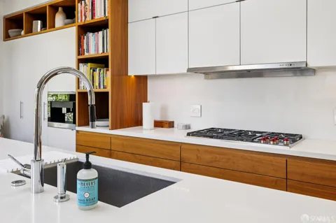 a kitchen with a sink a stove and cabinets