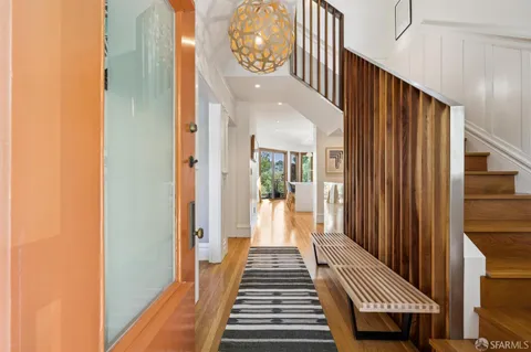 a view of a hallway with wooden floor and stairs