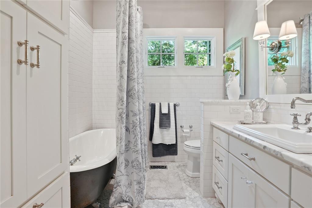 745 Washington Street Clarkesville, GA 30523 - Photo 36 of 54 a bathroom with a granite countertop sink a toilet and a bathtub