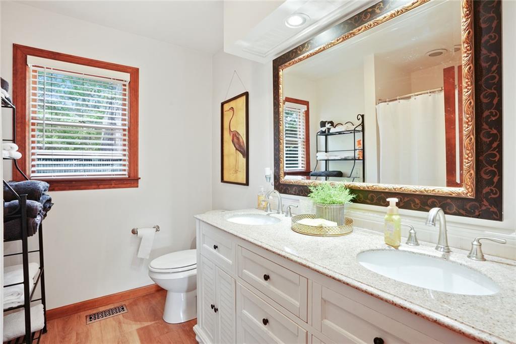 745 Washington Street Clarkesville, GA 30523 - Photo 49 of 54 a bathroom with a granite countertop double vanity sink a mirror and a toilet
