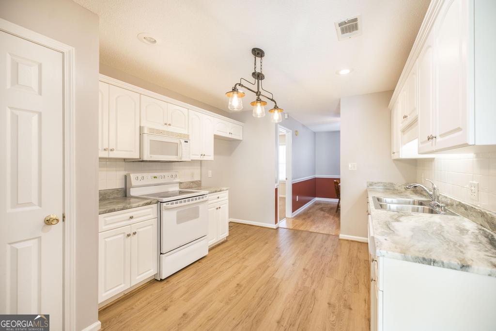 209 Mossy Ridge Warner Robins, GA 31088 - Photo 14 of 38 a kitchen with a sink a stove cabinets and wooden floor