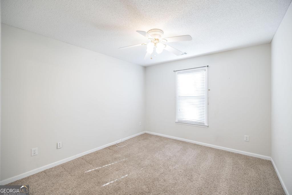 209 Mossy Ridge Warner Robins, GA 31088 - Photo 18 of 38 an empty room with a window and a chandelier fan