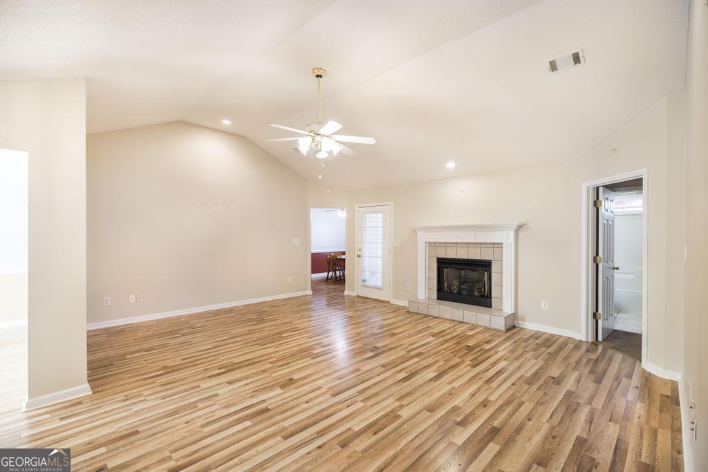 209 Mossy Ridge Warner Robins, GA 31088 - Photo 8 of 38 an empty room with wooden floor fireplace and windows